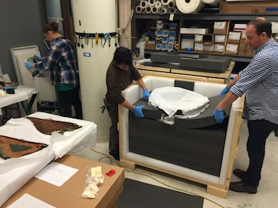 Wearing protective gloves, our team unpacks masks from their heavily padded crates.