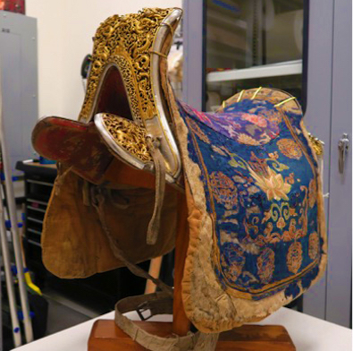 Saddle; Tibet or Mongolia; 18th or 19th century; Cloth, silk, leather, wood, iron, gilding, pigment; Rubin Museum of Art; Gift of the Family of Leon J. Weil; C2013.13. Currently on view in 